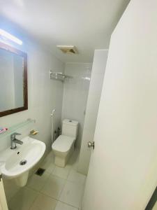 a white bathroom with a sink and a toilet at Studio apartment nearby Dhaka airport in Dhaka