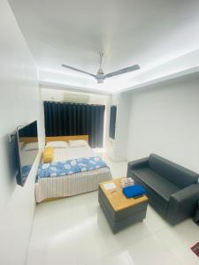 a bedroom with a bed and a couch at Studio apartment nearby Dhaka airport in Dhaka