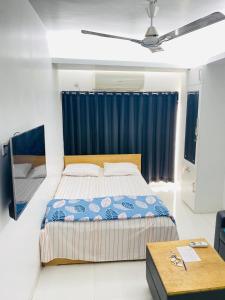 a bedroom with a bed and a blue curtain at Studio apartment nearby Dhaka airport in Dhaka