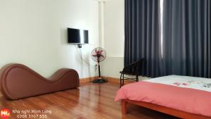 ein Schlafzimmer mit einem Bett und einem Ventilator in einem Zimmer in der Unterkunft NHÀ NGHỈ DU LỊCH MINH LONG - Quảng Trường in Cao Bằng