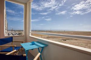 a table and chairs on a balcony with a view of the beach at Varandas do Oásis in Figueira da Foz