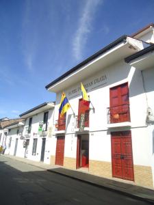 a building with two flags on a street at Hotel Popayan Plaza in Popayan