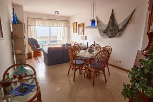 a living room with a table and chairs at Varandas do Oásis in Figueira da Foz