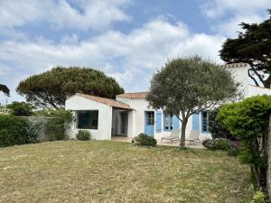 una casa bianca con un albero in cortile di Maison Noirmoutier-en-l'Île, 4 pièces, 6 personnes - FR-1-224B-75 a Noirmoutier-en-l'lle