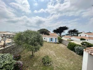 una casa bianca con un albero in un cortile di Charmante maison avec accès direct plage, jardin clos, 6 couchages, et ménage inclus - Noirmoutier - FR-1-224B-75 a Noirmoutier-en-l'lle