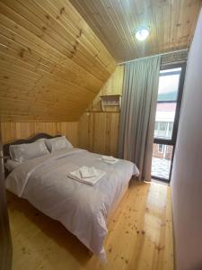 een bed in een houten kamer met een groot raam bij Kirta in Bangveti