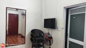 Zimmer mit einem Spiegel, einem Stuhl und einem TV in der Unterkunft NHÀ NGHỈ DU LỊCH MINH LONG - Quảng Trường in Cao Bằng