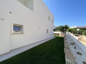 an external view of a white house with green grass at Al Mare da Francesca in Olbia