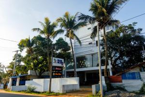 a building with palm trees in front of it at Pearl Island Inn in Jaffna