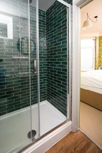 uma casa de banho com um chuveiro com azulejos verdes em Settle in Southampton - Self Check-In Serviced Rooms & Suites em Southampton