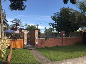 una valla de ladrillo con puerta de madera en un patio en Bello Bungalow, en Batukliang