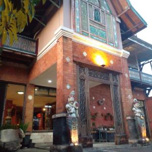 ein Gebäude mit einer Statue davor in der Unterkunft Hotel Bifa Yogyakarta in Yogyakarta