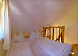 シュラートミンクにあるDependance IIの寝室にある白いシーツと枕が置かれたベッド