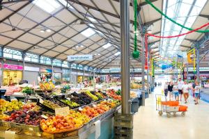 a market with fruits and vegetables and people walking through it at Varandas do Oásis in Figueira da Foz