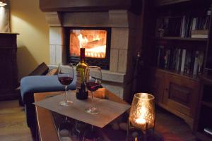 two glasses of wine on a table in front of a fireplace at Casa Rural Galain in Lizaso