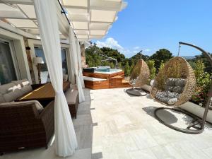 une terrasse avec des chaises et une baignoire dans une maison dans l'établissement Suite Villa Aquamarina con Jacuzzi Riservata, à Porto Pino