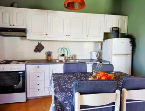a kitchen with a table with blue chairs and a sink at Seaside Escape Apartment in Gournes