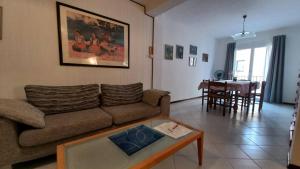 ein Wohnzimmer mit einem Sofa und einem Tisch in der Unterkunft Casa Martina "holiday home" Marano Lagunare in Marano Lagunare