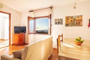 een woonkamer met een eettafel en een raam bij Casa Sui Tetti in Baunei