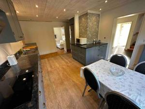 a kitchen with a table with chairs and a room with a kitchen at Östavall Kölsillre Lyxvilla, fiber internet WiFi in Haverö +71 photos