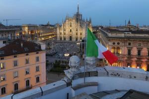 una vista de una ciudad con dos banderas en un edificio en PRESTIGE BOUTIQUE APARTHOTEL - Piazza Duomo View, en Milán