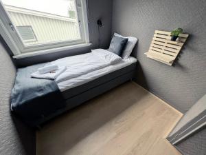 a small bed in a room with a window at Big central house, free parking, wifi, 3 bedrooms in Narvik