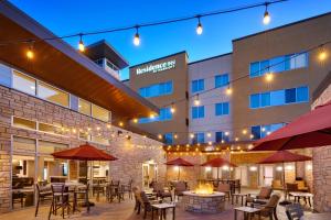 an outdoor patio with tables and chairs in front of a hotel at Residence Inn by Marriott Provo South University in Provo