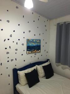 1 dormitorio con 1 cama con estrellas negras en la pared en Saquarema hospedagem en Saquarema