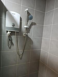 a shower with a blow dryer in a bathroom at QAISARA D'SAVANNA HOMESTAY@SOUTHVILLE CITY in Bangi