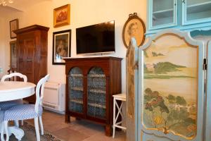 a living room with a tv on a wall at Ai Leoni Ruggenti - Suite dei Tesori Antichi in Monferrato in Ottiglio