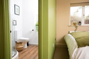 a bedroom with green walls and a bed and a bathroom at Settle in Southampton in Southampton