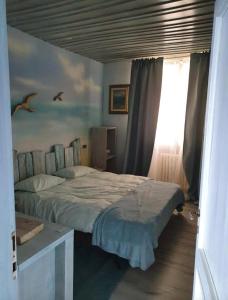 een slaapkamer met een bed met vogels aan de muur bij Hammer House in Porlezza