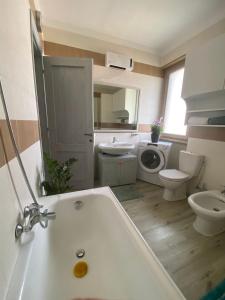een badkamer met een bad, een toilet en een wastafel bij Hammer House in Porlezza