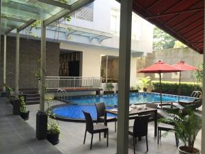 a patio with a table and chairs and a pool at Hotel Permata Bogor in Bogor