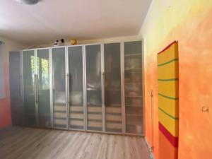 een kamer met een kast met glazen deuren bij Hammer House in Porlezza