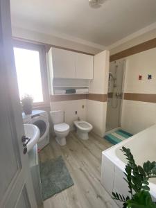een badkamer met een toilet, een wastafel en een douche bij Hammer House in Porlezza