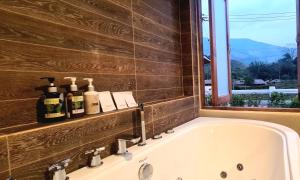 a bath tub in a bathroom with a window at Times Klang Sapan Resort 