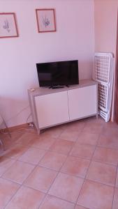 uma sala de estar com televisão num armário branco em Scano Comfort Inn em Santa Teresa Gallura
