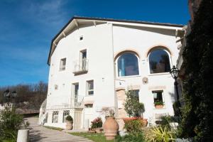 a large white building with windows and plants at Ai Leoni Ruggenti - Suite dei Tesori Antichi in Monferrato in Ottiglio