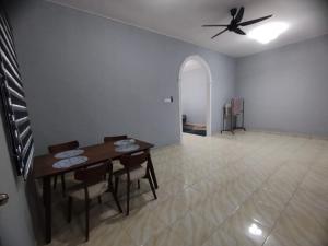 a dining room with a table and a ceiling fan at DAHLIA HOMESTAY Batu Pahat in Batu Pahat