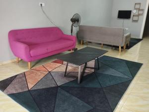 峇株巴辖DAHLIA HOMESTAY Batu Pahat的客厅配有粉红色的沙发和桌子