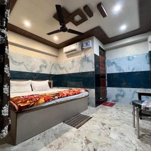 een slaapkamer met een groot bed en een plafondventilator bij Hotel Raghunandan Near Shree Ram Janambhumi in Ayodhya