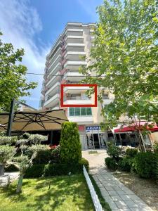 un edificio con un cartello rosso sul lato di Dream Home a Vlorë
