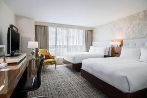 a hotel room with two beds and a television at Renaissance Baton Rouge Hotel in Baton Rouge