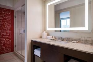 a bathroom with a sink and a mirror and a shower at Renaissance Baton Rouge Hotel in Baton Rouge
