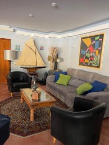 a living room with a couch and chairs and a table at Quinta Dos Amarelos no Meco in Aldeia do Meco