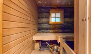 a sauna with a wooden wall and a window at Holiday Apartments Aurinkosuomu in Kemijärvi