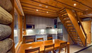 a kitchen with a wooden table and a staircase in a cabin at Holiday Apartments Aurinkosuomu in Kemijärvi