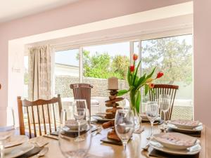 a dining room with a table with wine glasses at Three Decks in Yapton