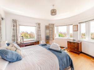 a bedroom with a large bed and two windows at Three Decks in Yapton